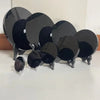 A collection of black obsidian scrying mirrors with silver stands arranged on a white surface.