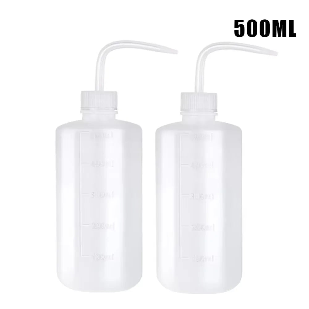 A pair of clear 500ml squeeze bottles with measurement lines for tattoo solutions