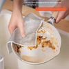 A hand is using a mesh cleaning rag to remove stains from a non-stick cooking dish.