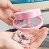 A hand holds a pink floating laundry mesh filter bag for hair and lint, demonstrating its use.