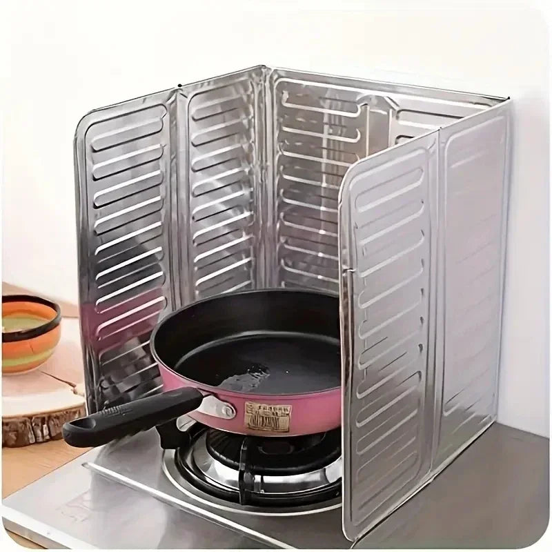 Klappbare Aluminium-Küchenherd-Spritzschutz mit einer rosa Pfanne auf dem Brenner.