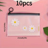 A set of ten clear plastic storage bags with a white daisy pattern and black zippers displayed on a pink background.