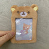 A fluffy brown Rilakkuma plush ID card holder keychain featuring a character illustration inside.