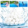 A pile of white eco-friendly pool filter cleaning balls surrounded by splashing water.