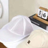A white mesh baseball cap is displayed next to a wooden box labeled June 6th.