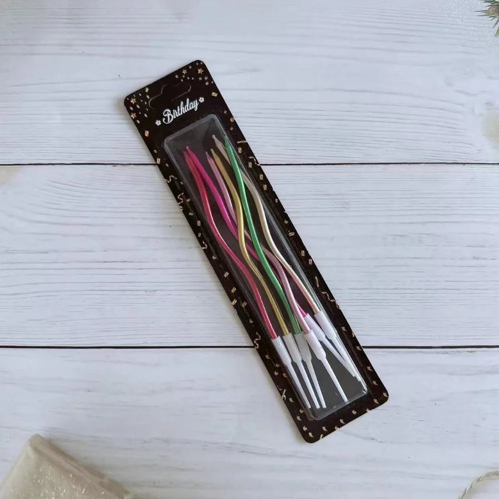 Ein Set dekorativer Spiralkerzen zum Geburtstag in verschiedenen Farben, präsentiert in einer dunklen Verpackung.
