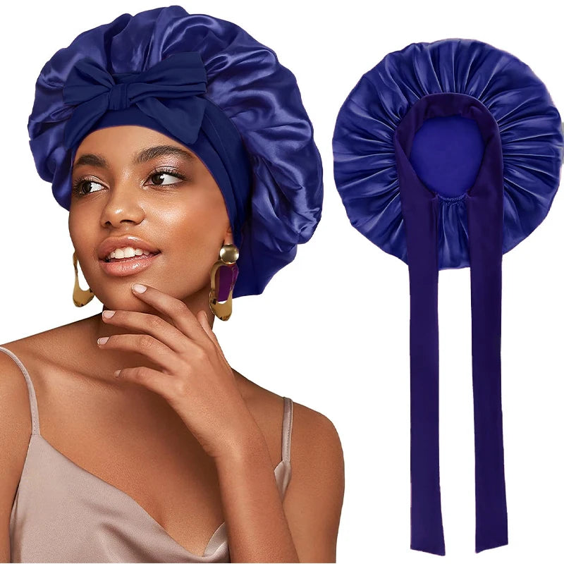A woman models a royal blue satin sleeping cap with an adjustable tie band.