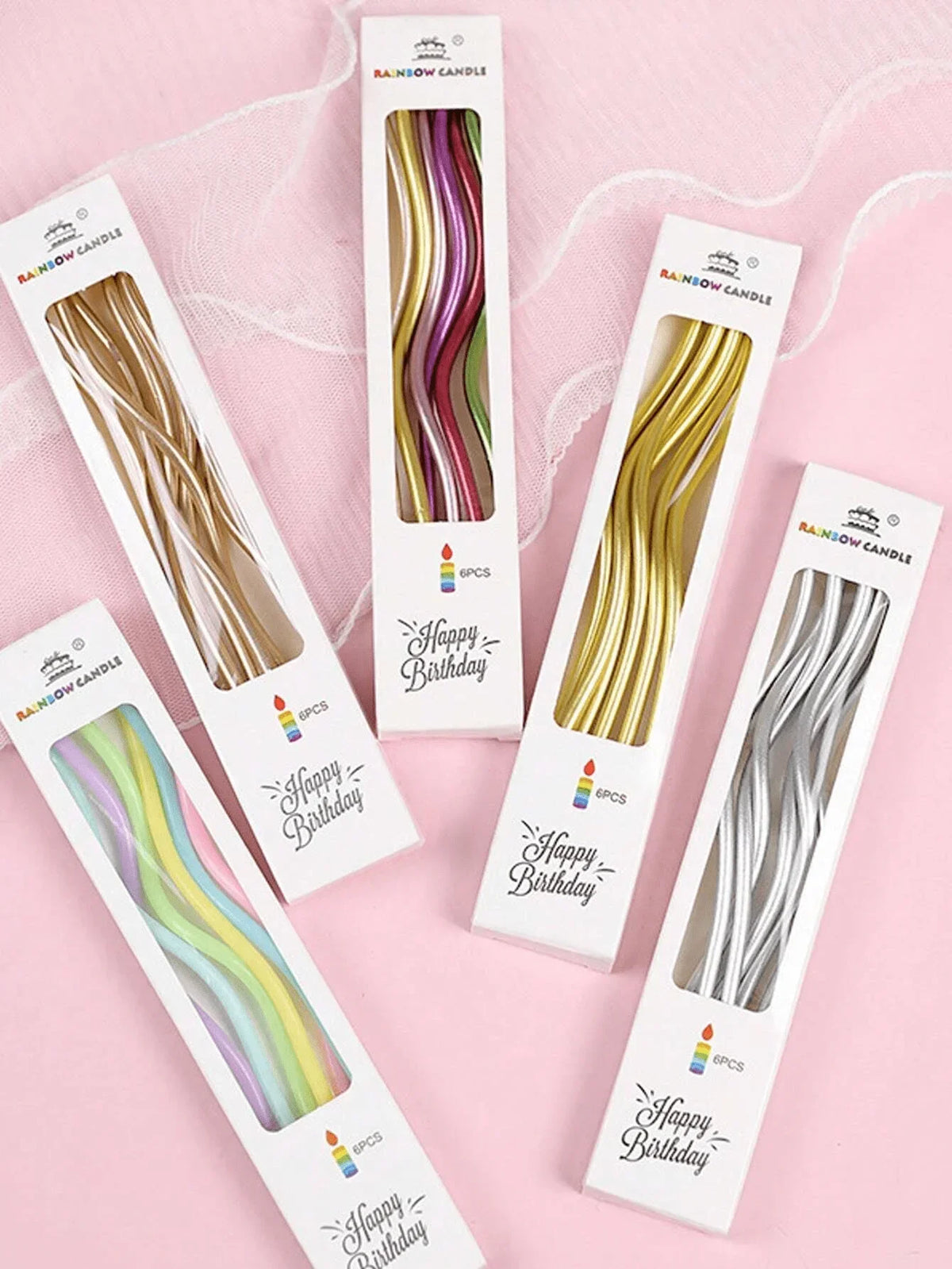 Ein Set Regenbogen-Spiral-Kerzen in verschiedenen Farben auf weißer Kartonverpackung.