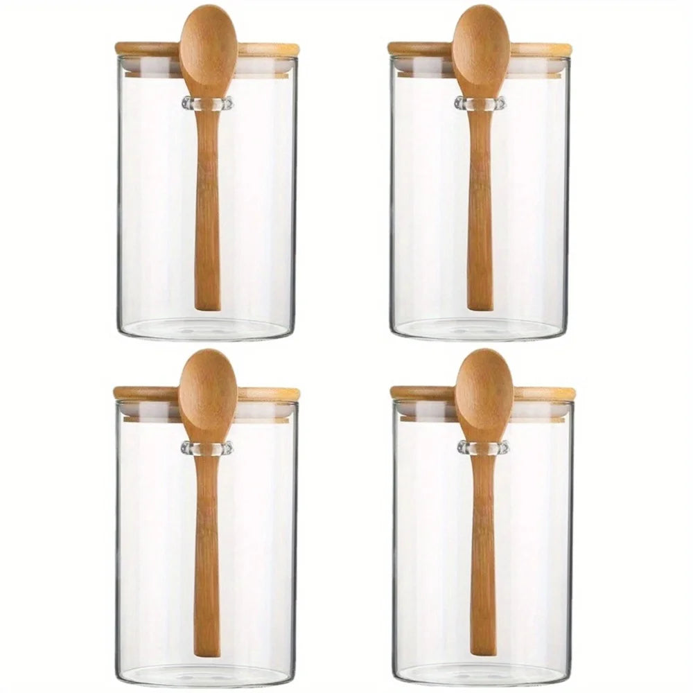 Four clear glass jars with wooden lids and stems used for meal prep