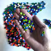 A hand holds a large collection of colorful round building blocks arranged in a curved pattern.