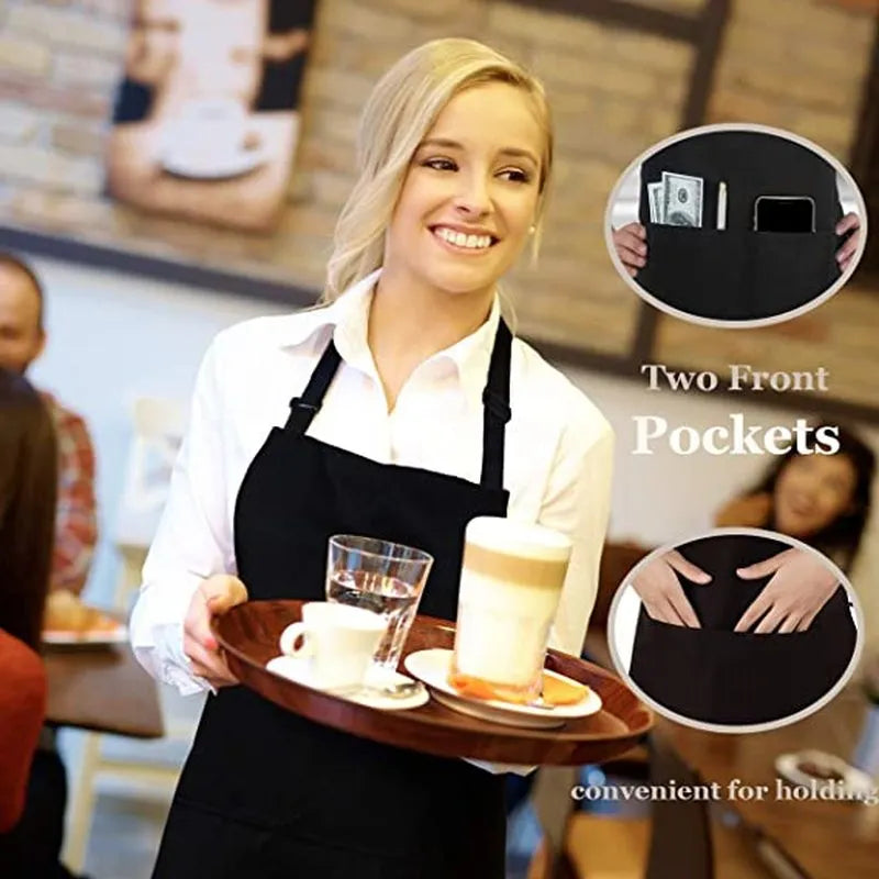 A blonde woman wearing a black cooking apron with two front pockets, holding a glass and a beverage cup.