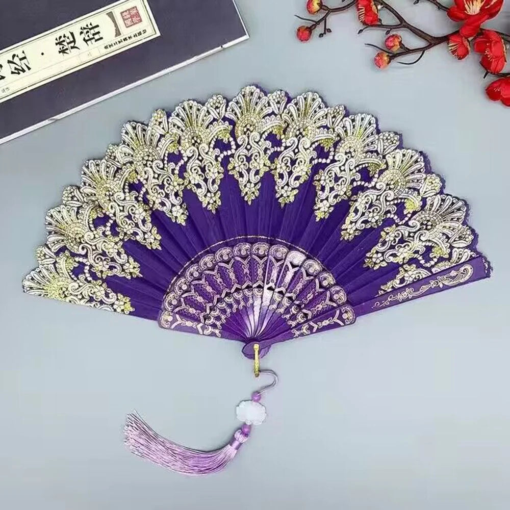 Purple and gold hand folding fan with intricate floral patterns