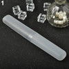 A clear plastic tube toothbrush case is shown next to several small, clear, cube-shaped objects and a glass jar containing wh