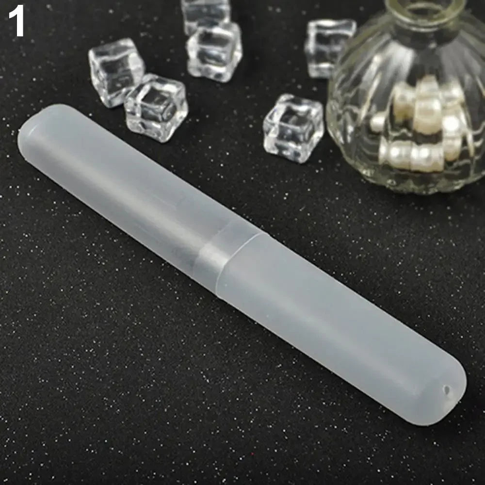 A clear plastic tube toothbrush case is shown next to several small, clear, cube-shaped objects and a glass jar containing wh