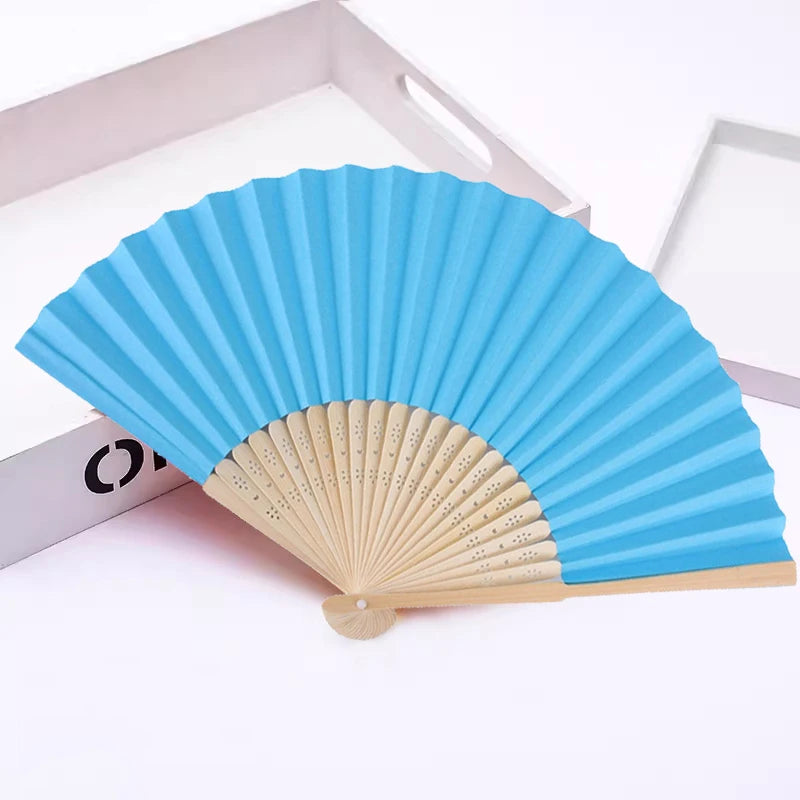 Un éventail pliable à la main fait de papier bleu et de bambou naturel.