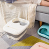 A light pink foldable foot soak bucket resting on a gray rug next to a sofa.