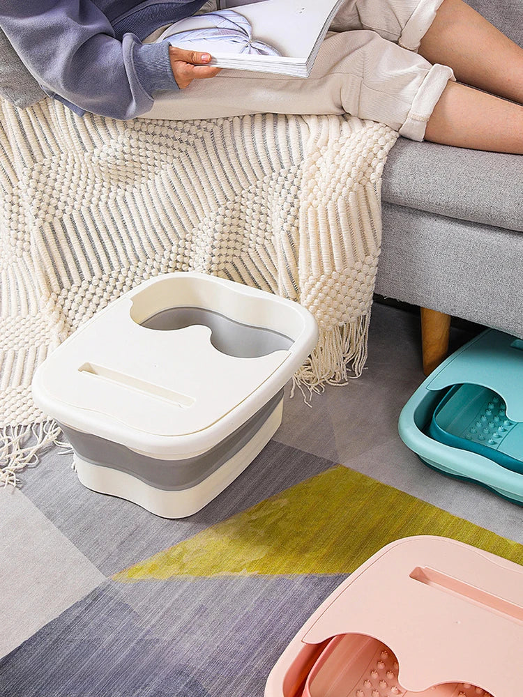 A close-up view of several light colored foldable foot soak buckets resting on a gray rug.