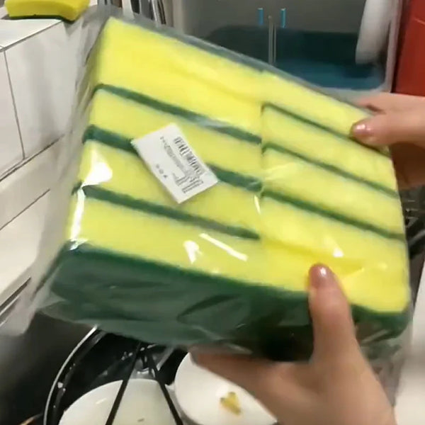 A clear plastic bag filled with bright yellow and green double-sided scouring sponges for kitchen cleaning.