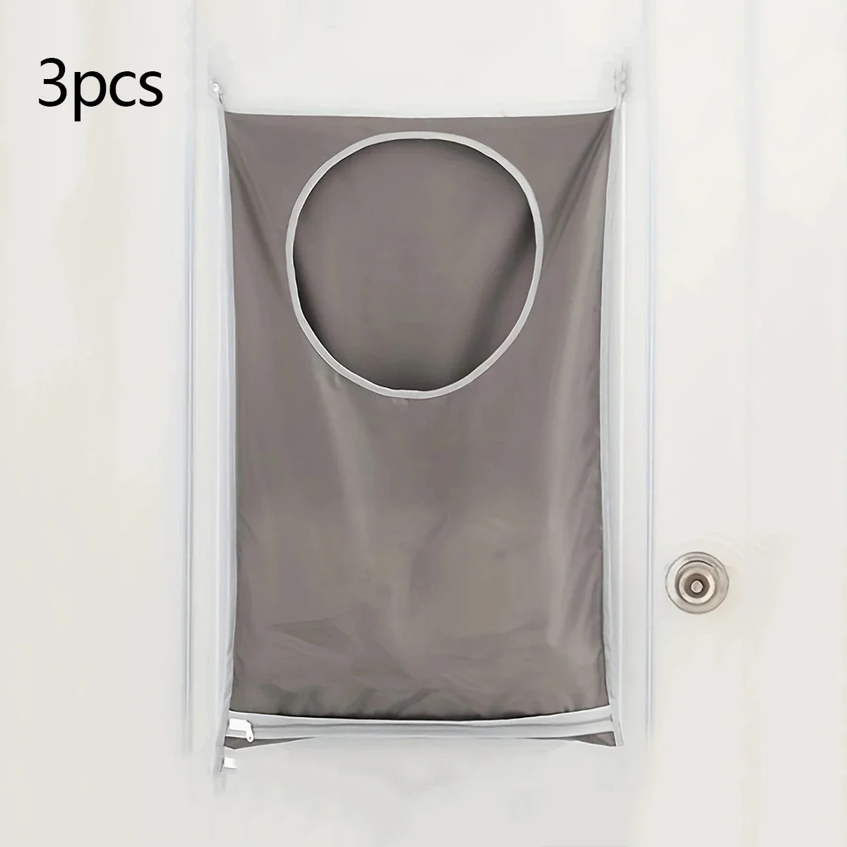 Three gray fabric laundry organizers with circular openings hanging on a white door.
