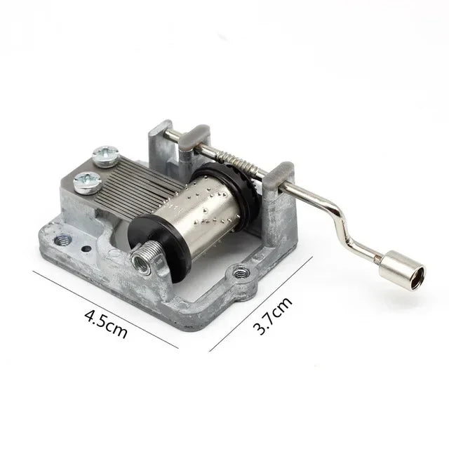 A silver hand crank mechanism for an antique wooden music box.