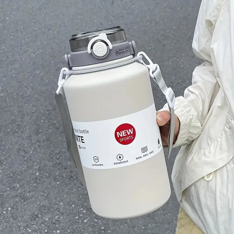 A large white stainless steel insulated tumbler with a silver lid and handle is held by a person.