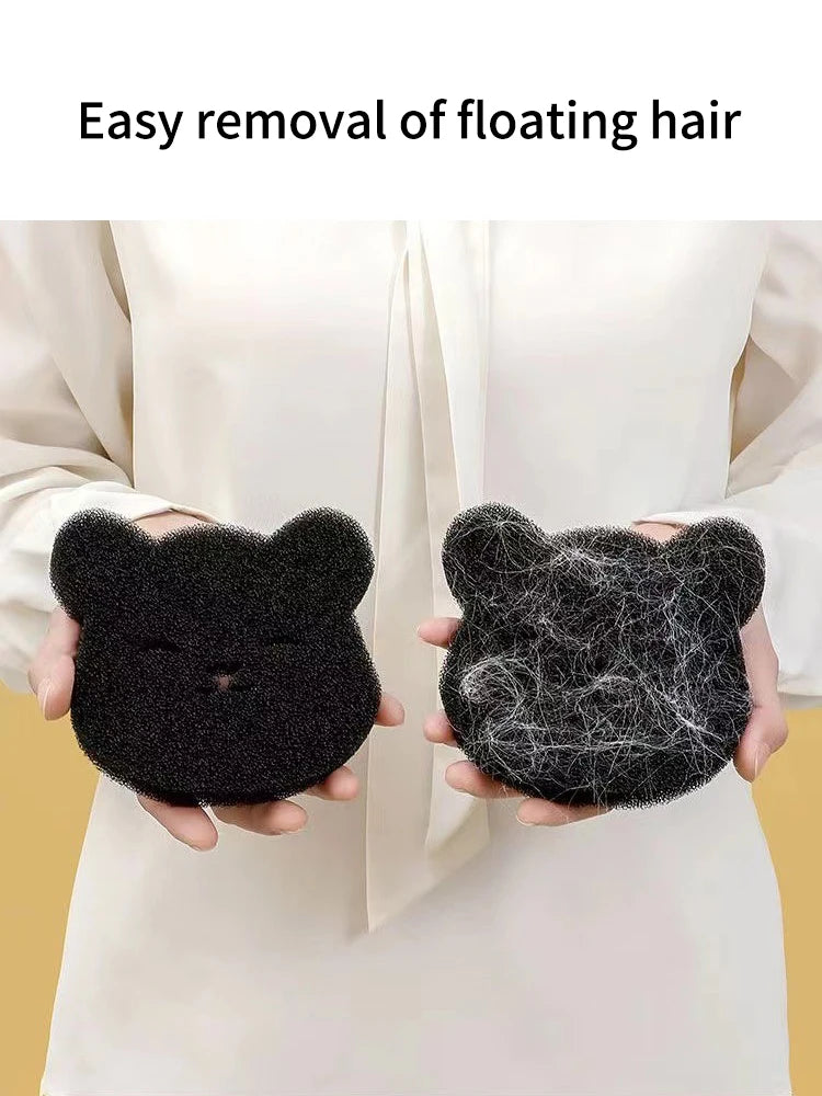 A black cat-shaped pet hair remover sponge is shown being used to remove floating hair from a person's clothing.