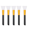 A set of six silicone facial mask brushes with gold and black handles.