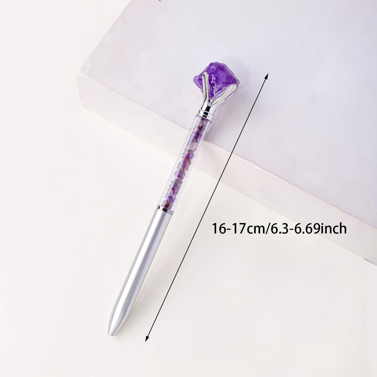 A silver crystal pen with a purple amethyst gemstone is shown against a white background.