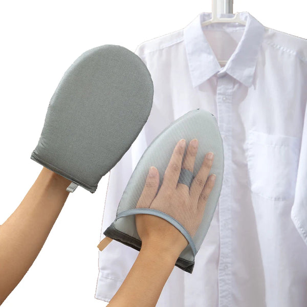 A hand holds a gray heat resistant ironing pad, which is attached to a white shirt hanging on a hanger.