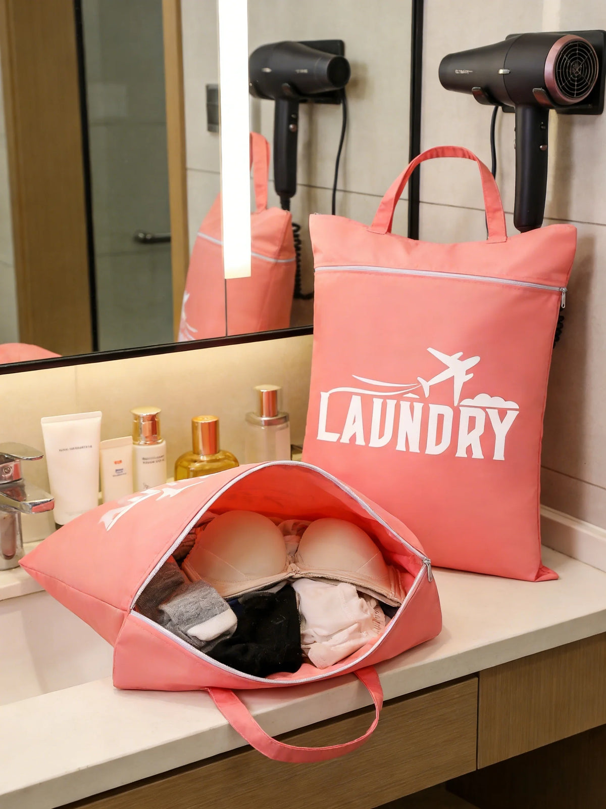 A pink laundry bag is displayed on a counter next to a mirror and other storage items.