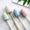 A set of four silicone toothbrush head covers in pastel colors including mint green, light beige, blue, and pink resting on a