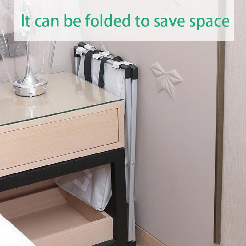 A foldable white laundry basket with black trim is shown next to a wooden table and a wall.