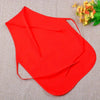 A bright red non-woven craft apron is shown against a beige fabric background.
