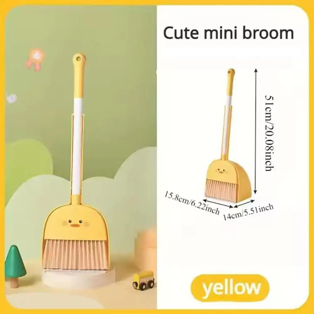A yellow mini broom with a handle and bristles is shown next to its dustpan in a light green background.