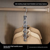 A 360 rotating single hook foldable aluminum space rack hanging six pieces of clothing on a wooden rod.