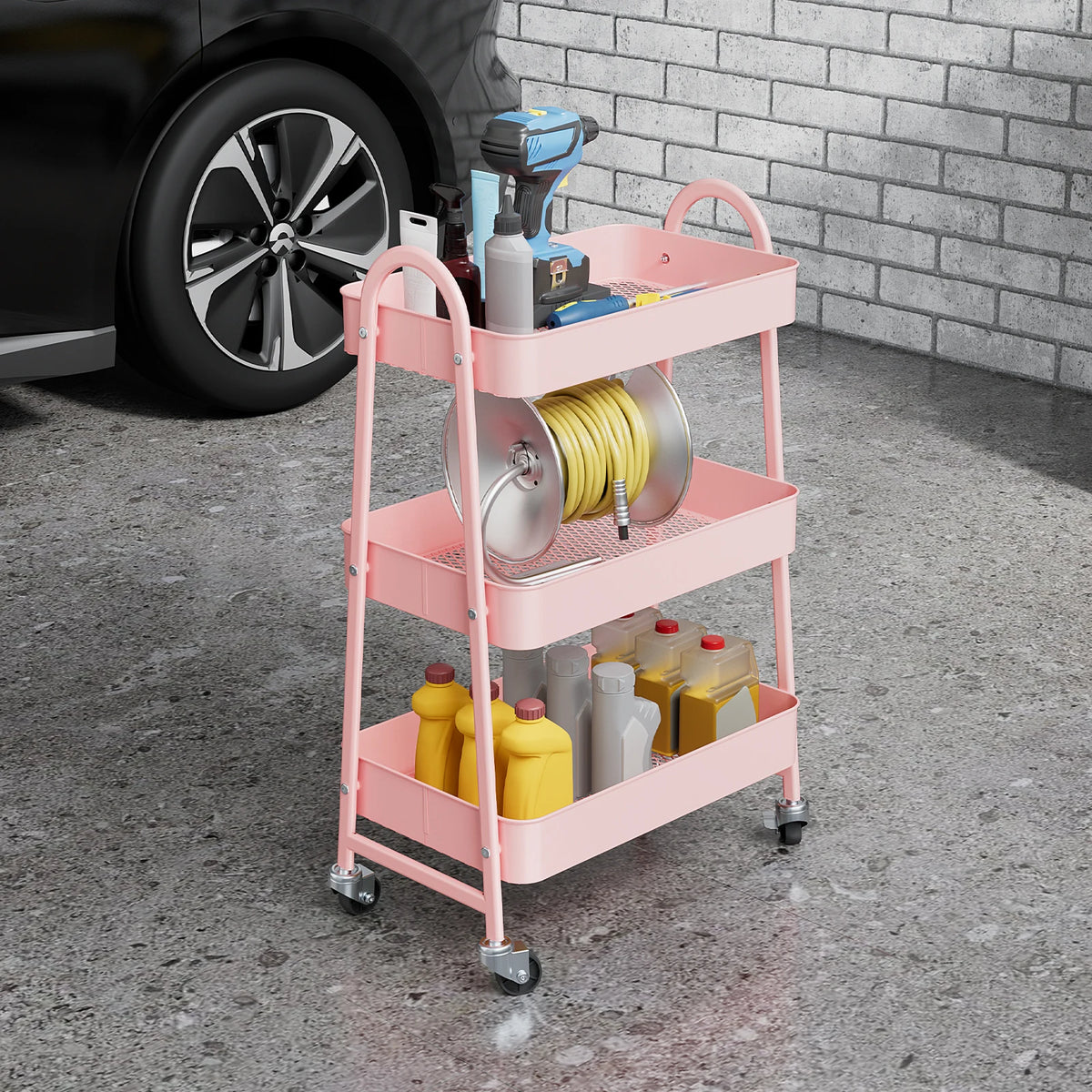 A pink 3-tier metal rolling storage cart filled with various tools and supplies, including a drill and coiled wire.