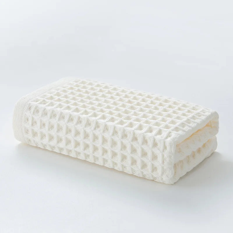 Weiches weißes Baumwoll-Waffeltuch-Badetuch-Set, gefaltet und auf weißer Oberfläche