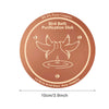 A round copper purification disk featuring an engraved bird bath design for purifying water.