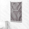 A gray foldable hanging laundry basket organizer is displayed against a white marble tiled wall.