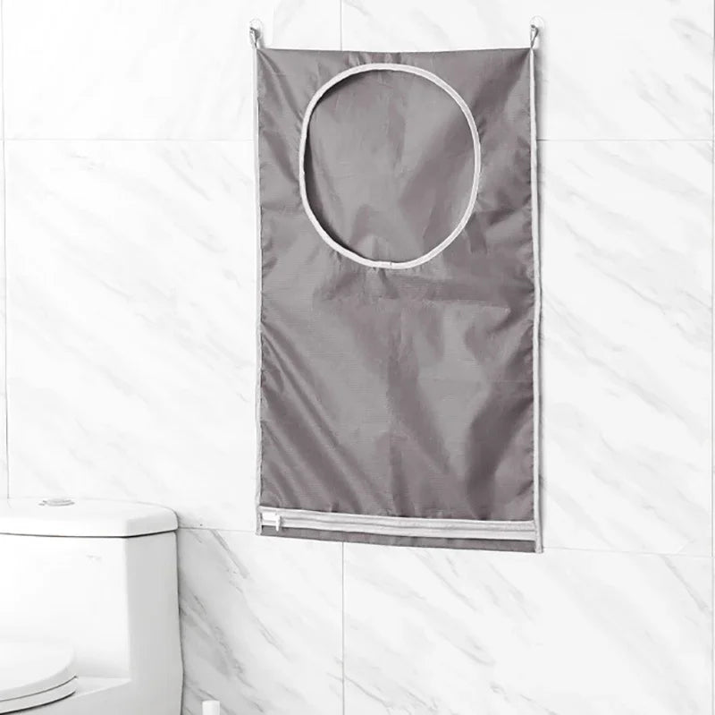 A gray foldable hanging laundry basket organizer is displayed against a white marble tiled wall.