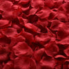 Primer plano de pétalos de rosa de seda artificial rojo intenso apilados.