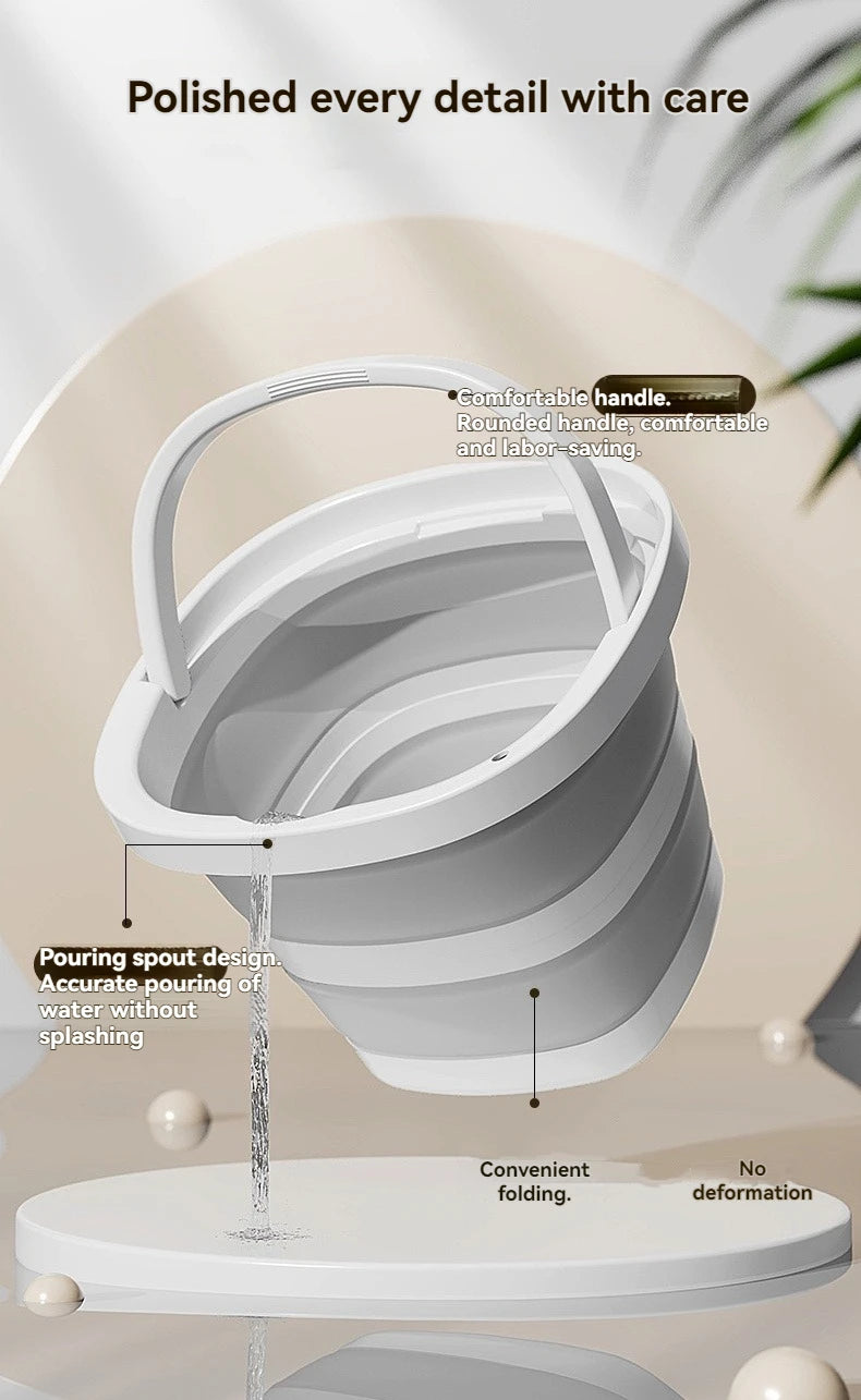 A white foldable plastic bucket with an arc handle is shown pouring water onto a flat base.