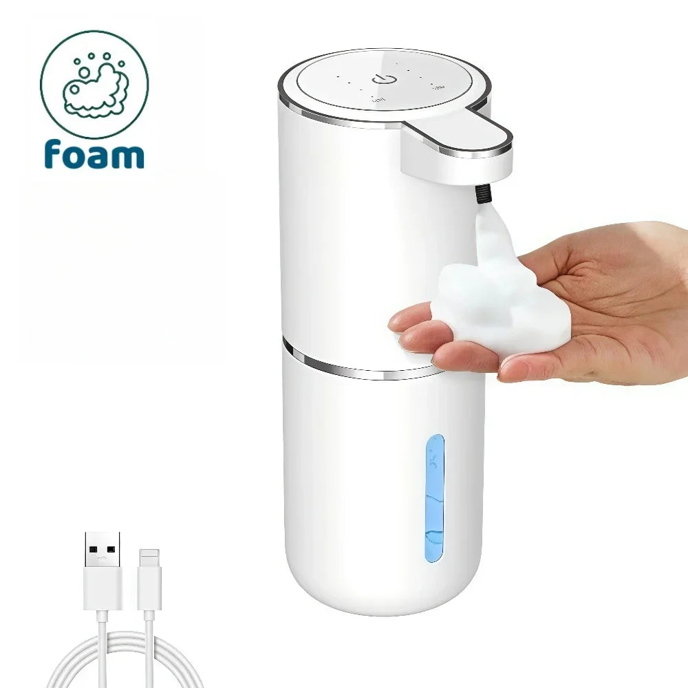 A hand is dispensing soap from a white touchless electric soap dispenser with a foam nozzle.