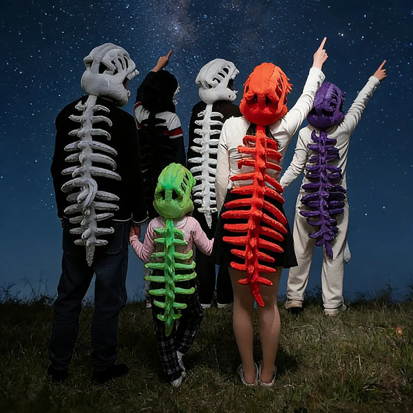 A group of people dressed in realistic dinosaur skeleton costumes posing outdoors under a starry night sky.