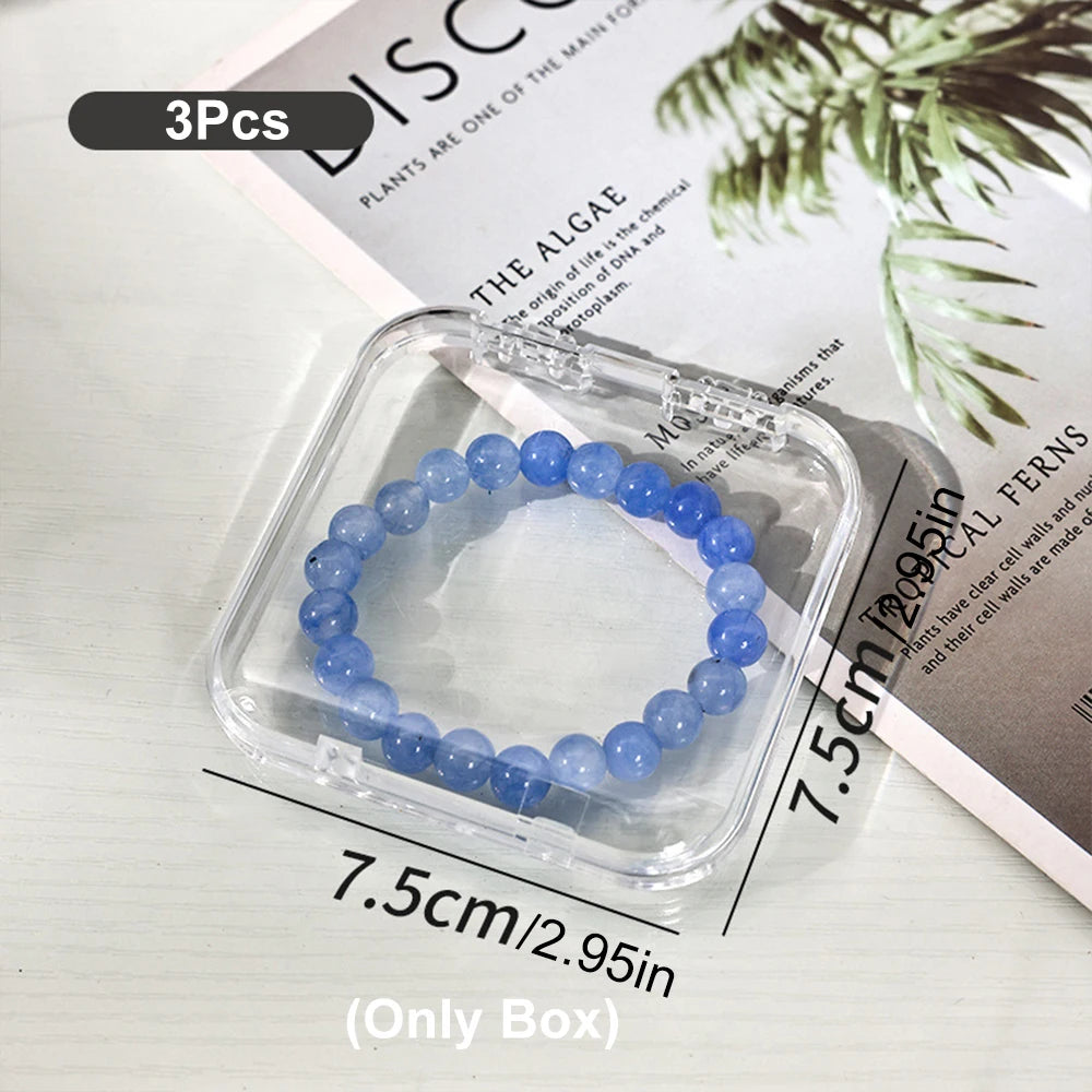A clear plastic jewelry organizer box containing a strand of blue beads, shown next to a plant informational page.