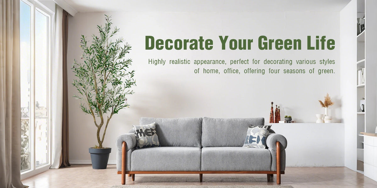 A gray sofa in a bright room with a large potted artificial olive tree and a wall sign encouraging decorating a green life.