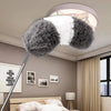 A white and gray fluffy duster is suspended from a pole, ready for deep cleaning in a modern bedroom setting.