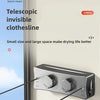A close-up of a black telescoping clothesline mounted on a wall, showing the locking and freeing mechanism.