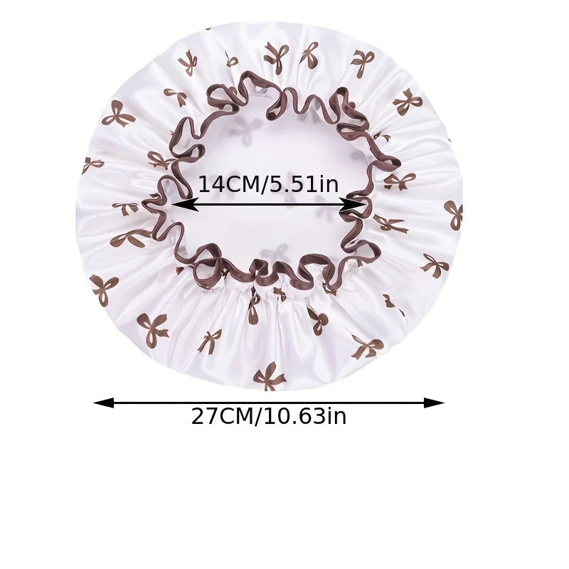White reusable double layer shower cap with brown decorative trim and measurements.
