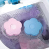 Pink and blue floating laundry mesh filter bags are visible inside a washing machine drum.